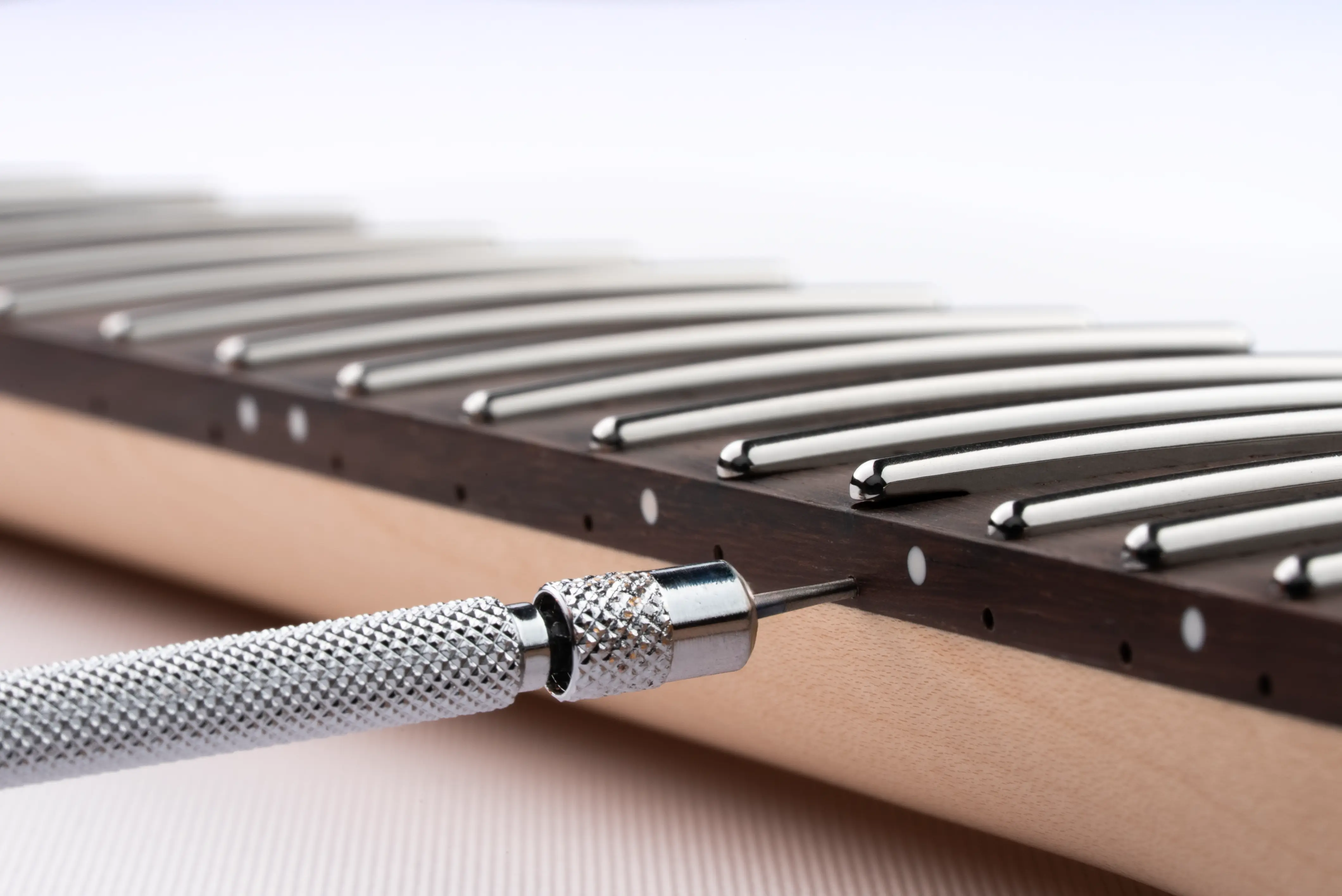 Fret height adjustment with hex key